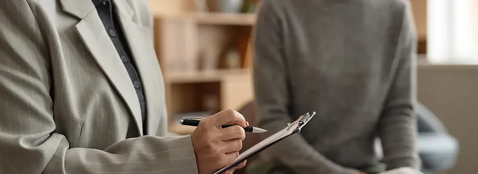 Female therapist holding clipboard taking notes