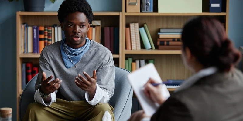 black teenage boy sharing feelings counseling session with