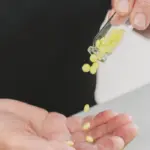 elderly woman pours yellow pills out bottle into