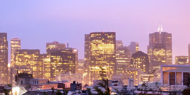 illuminated buildings city against sky
