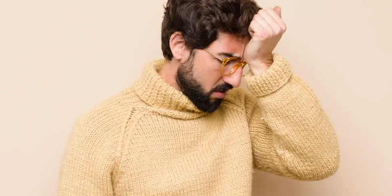 looking stressed tired frustrated drying sweat off forehead