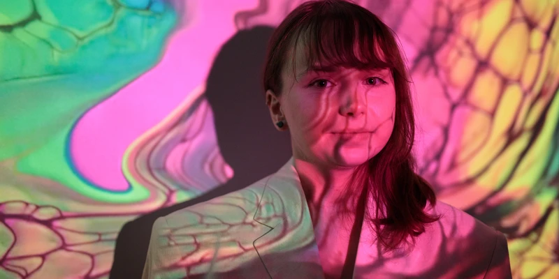 portrait young woman standing against wall