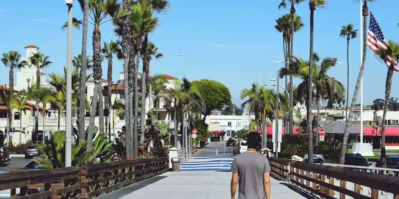 rear view man walking footbridge against sky