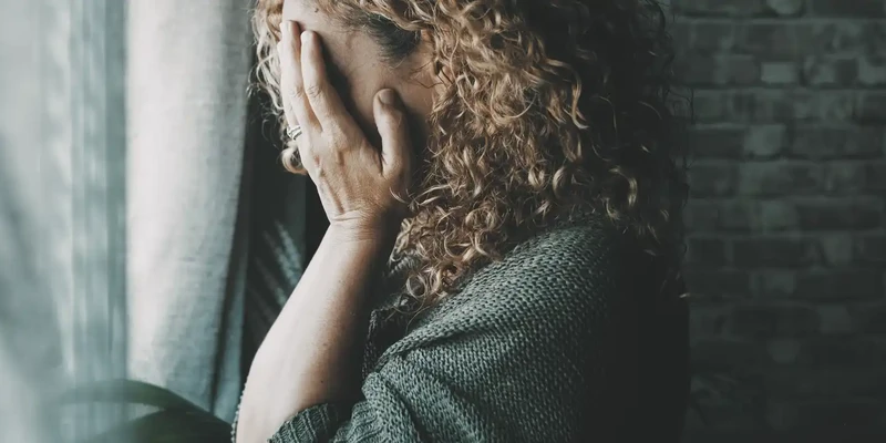 sad worried woman side portrait home dark looking