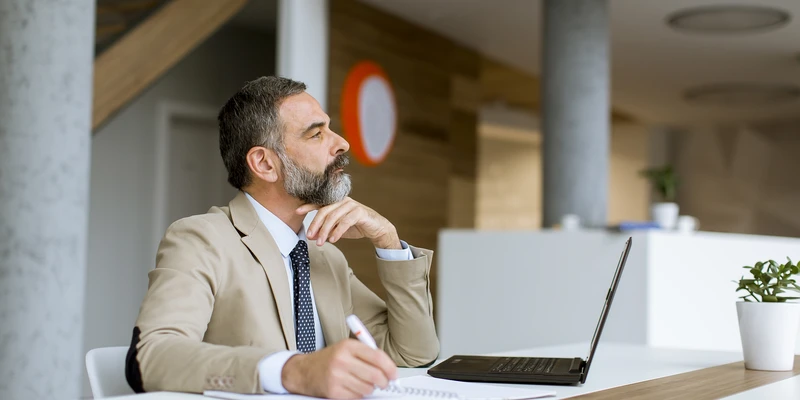 senior businessman gray hair working laptop modern office