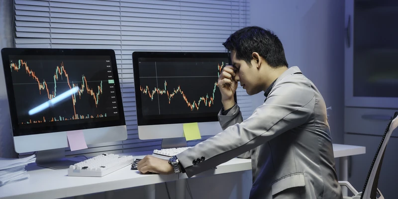 stressed stock trader looking falling stock market chart