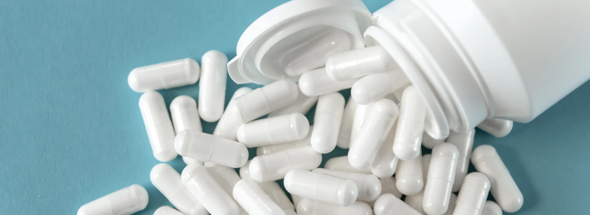 white tabletts pills blue background