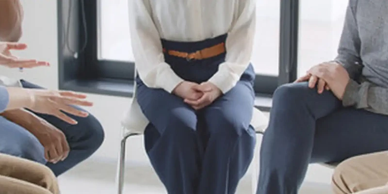 woman sits chair with woman white shirt blue